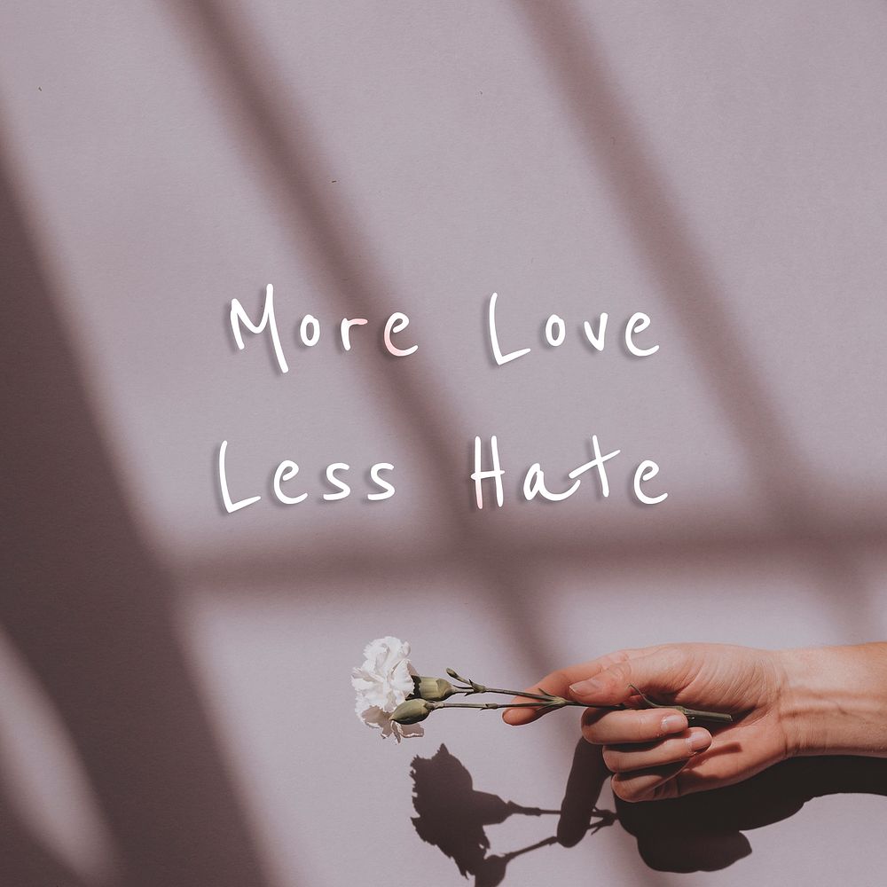 More love less hate quote on a hand holding flower background