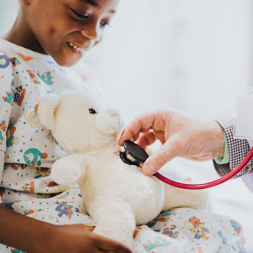 Pediatrician checking teddy bear's heart beat