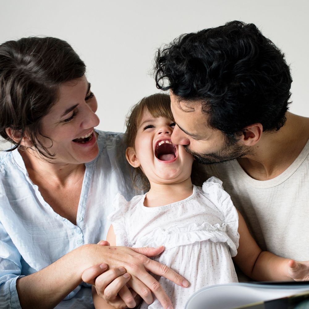 Happy parents laughing together with daughter