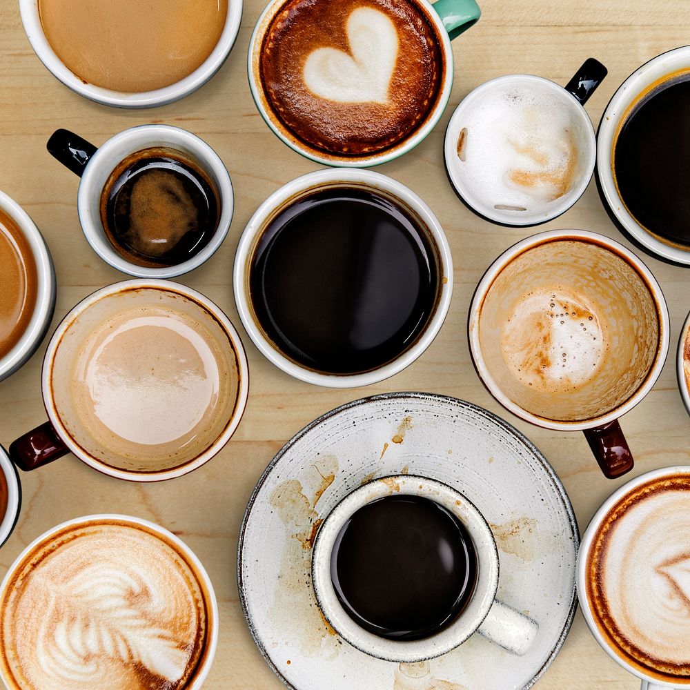 Assorted coffee cups on a light brown wooden board