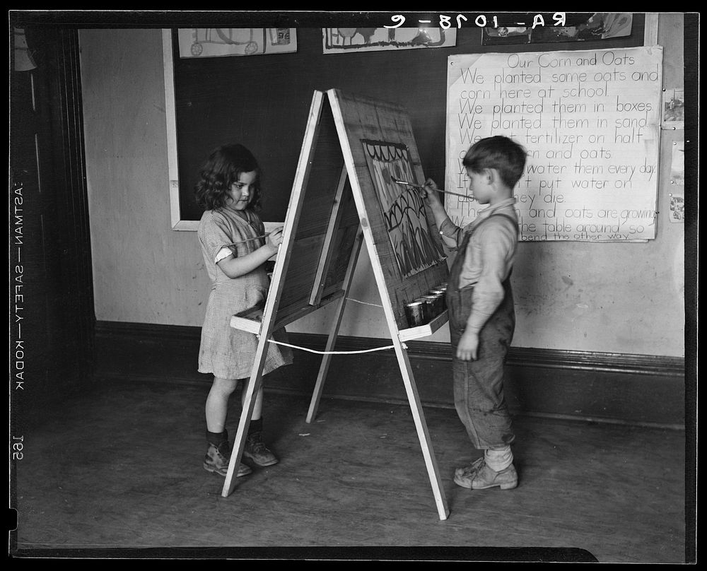 First grade boy and girl at drawing board in schoolroom. Reedsville, West Virginia. Sourced from the Library of Congress.