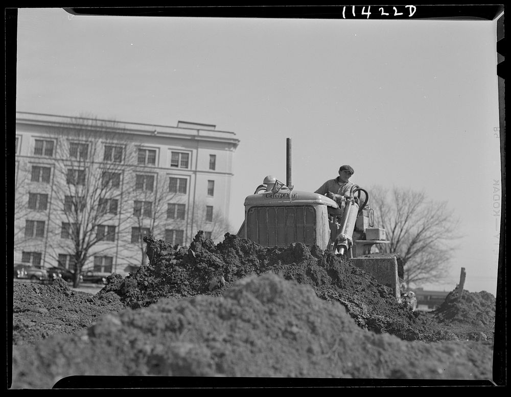 Washington, D.C. Construction of a bridge and road near Independence Avenue and 14th and 16th Streets, S.W. Bulldozer moving…