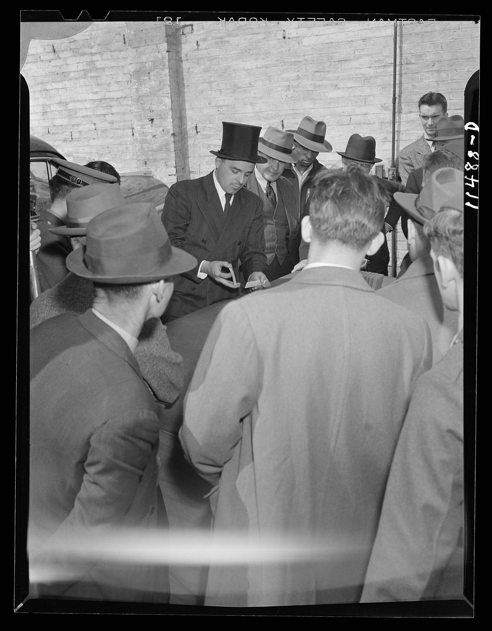 Washington, D.C. Barker demonstrating a trick deck of cards on 9th between E and F Streets, N.W.. Sourced from the Library…