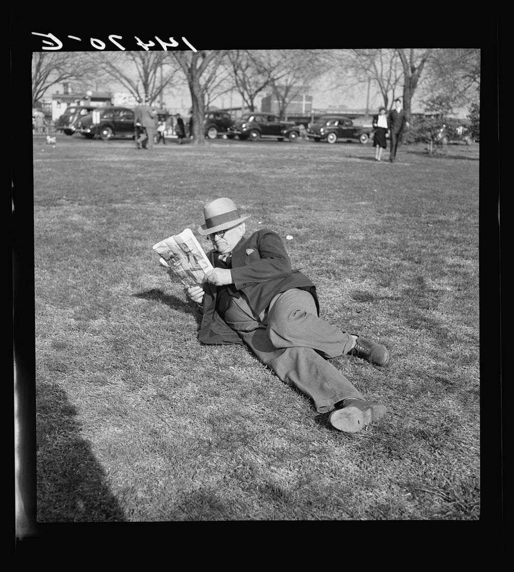 Looking at pitures in the park. Washington, D.C.. Sourced from the Library of Congress.