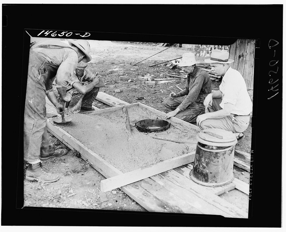Placing concrete in form for privy slab. Minnesota. Sourced from the Library of Congress.