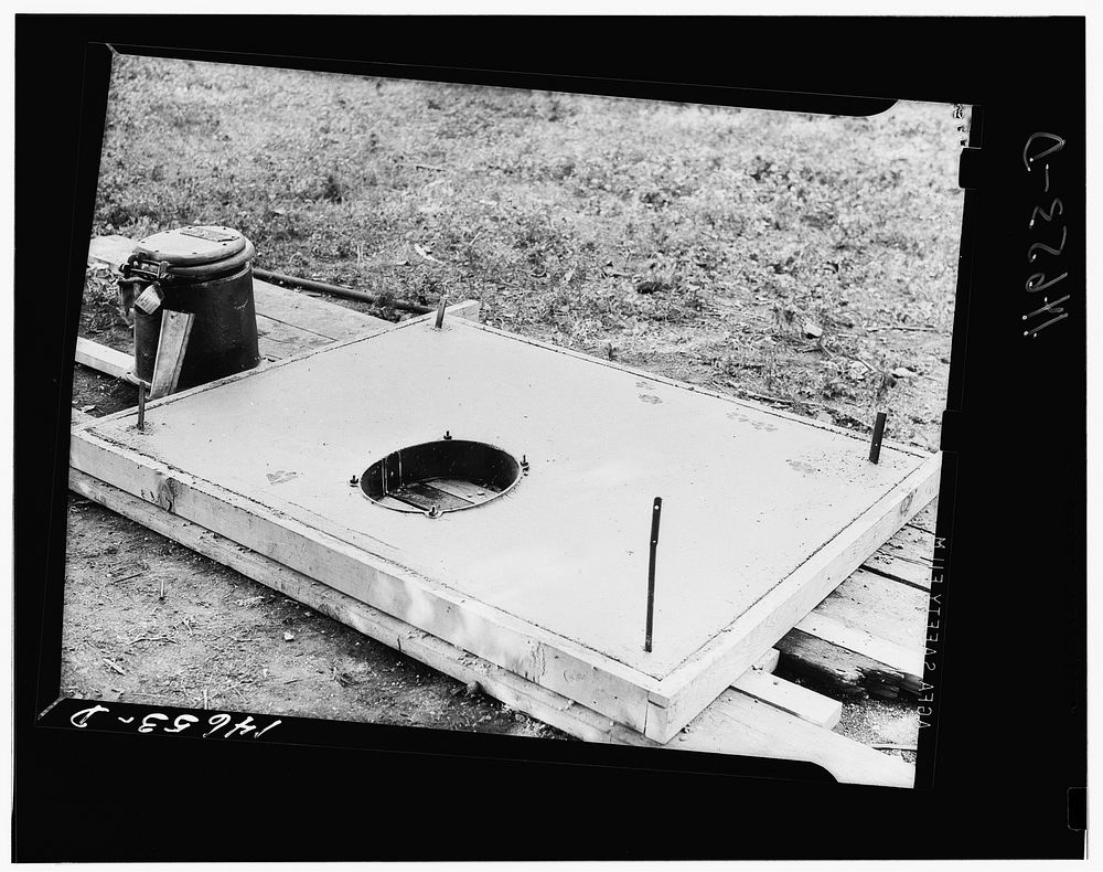 Concrete slab for sanitary privy. The stool at the left bolts on to the collar. The building is fastened to metal strips at…