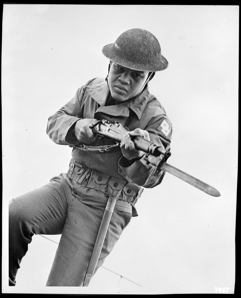[Untitled photo shows: heavyweight boxing champion Joe Louis charging with bayoneted rifle]. Sourced from the Library of…