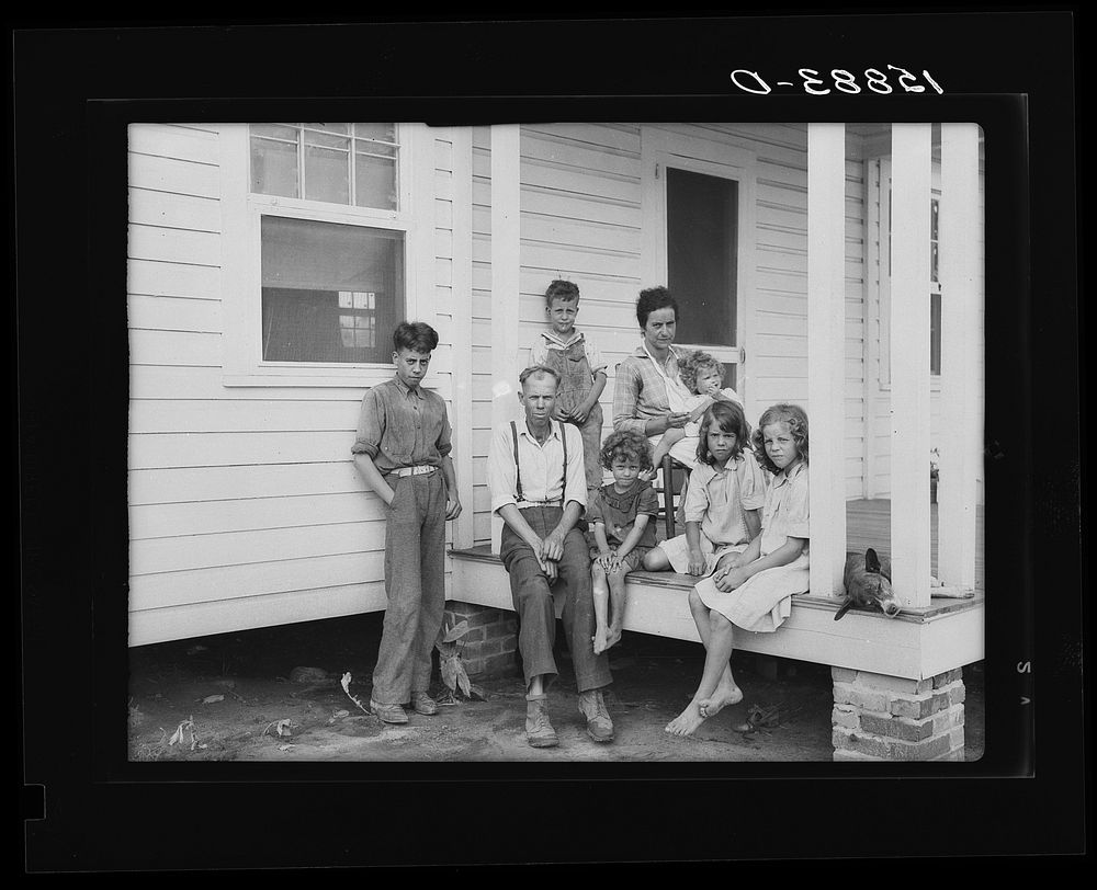 John Bunyan Locklear and family on porch of new home. Pembroke Farms, North Carolina. Sourced from the Library of Congress.