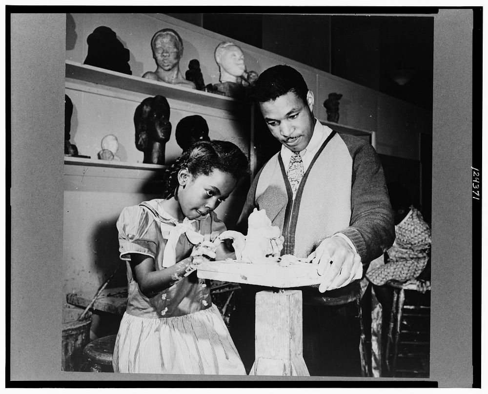 Teacher and girl modeling clay. Sourced from the Library of Congress.