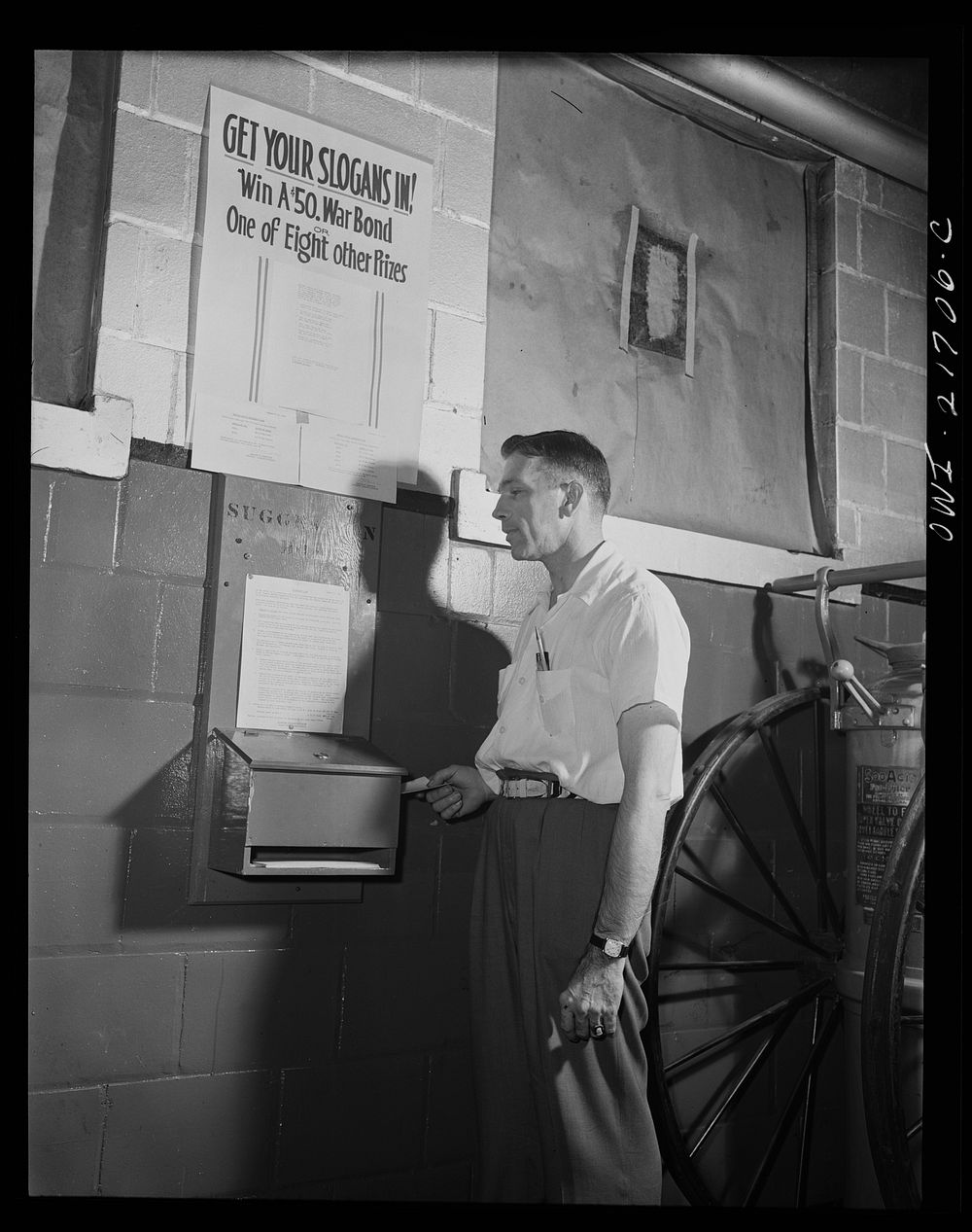 Rochester, New York. Mr. Babcock using the suggestion box at the plant to submit an idea for saving time. Sourced from the…