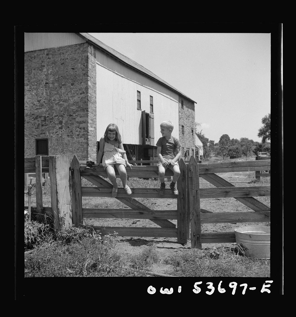 Dresher, Pennsylvania. Children sitting on a fence in front of a barn at the Spring Run Farm. Sourced from the Library of…