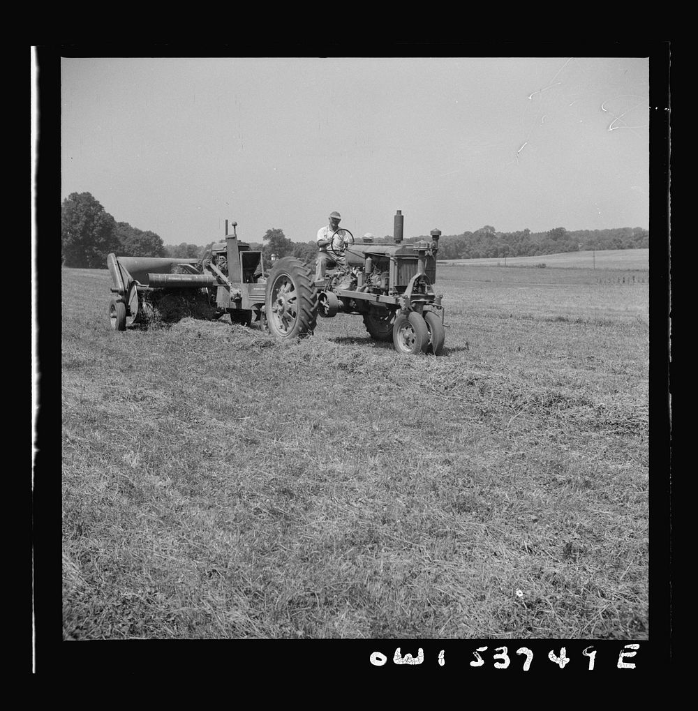 Dresher, Pennsylvania. Operating a hay baling machine at the Spring Run Farm. Sourced from the Library of Congress.