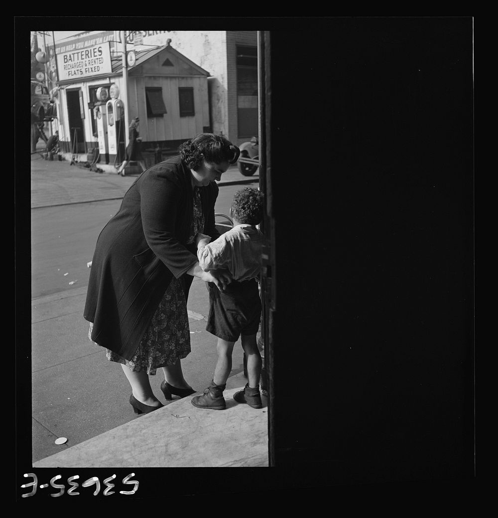 New York, New York. A small boy who receives day care at Greenwich House while his mother works being called for at the end…