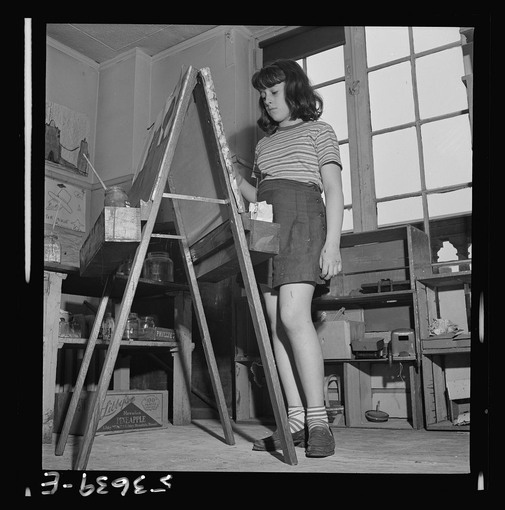 New York, New York. A young girl working on an oil painting during after school hours at Greenwich House, a community center…