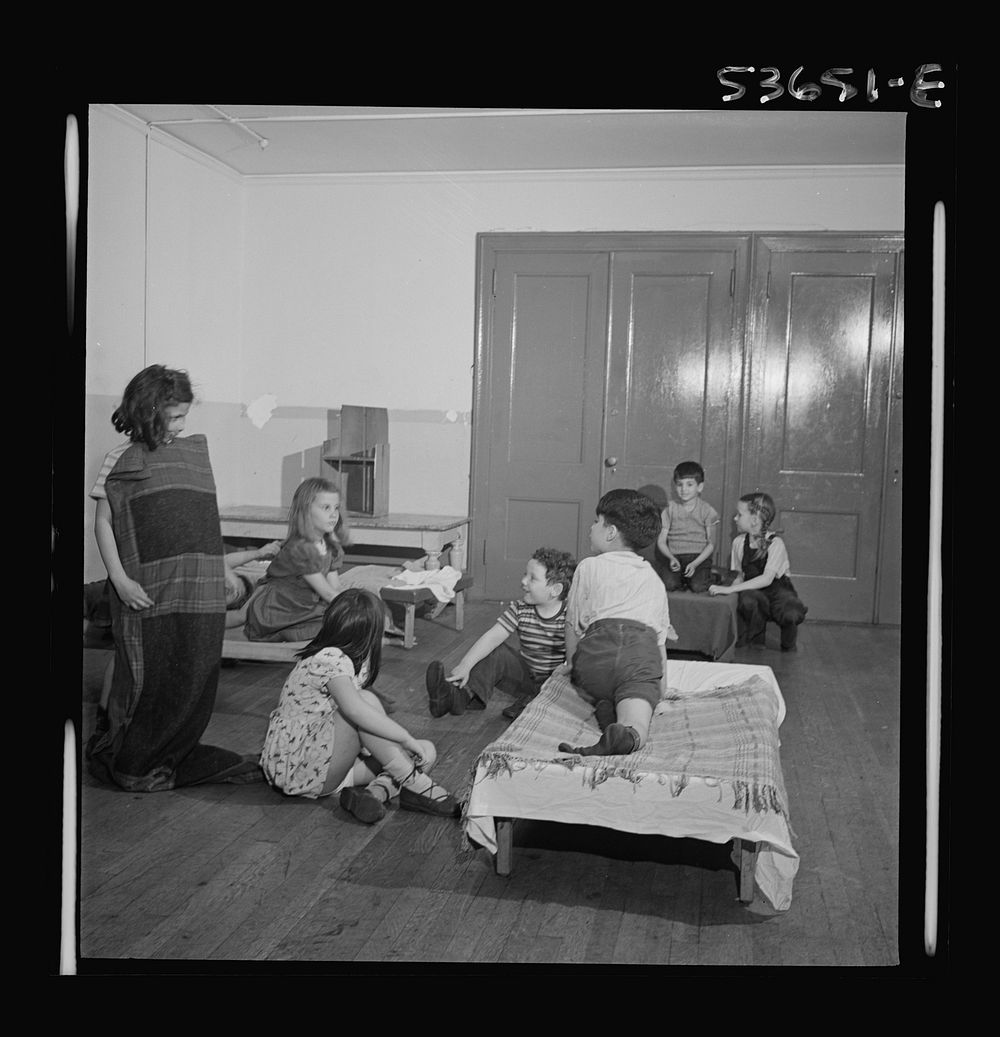 New York, New York. Children putting on their shoes after a rest period at Greenwich House where they receive day care while…