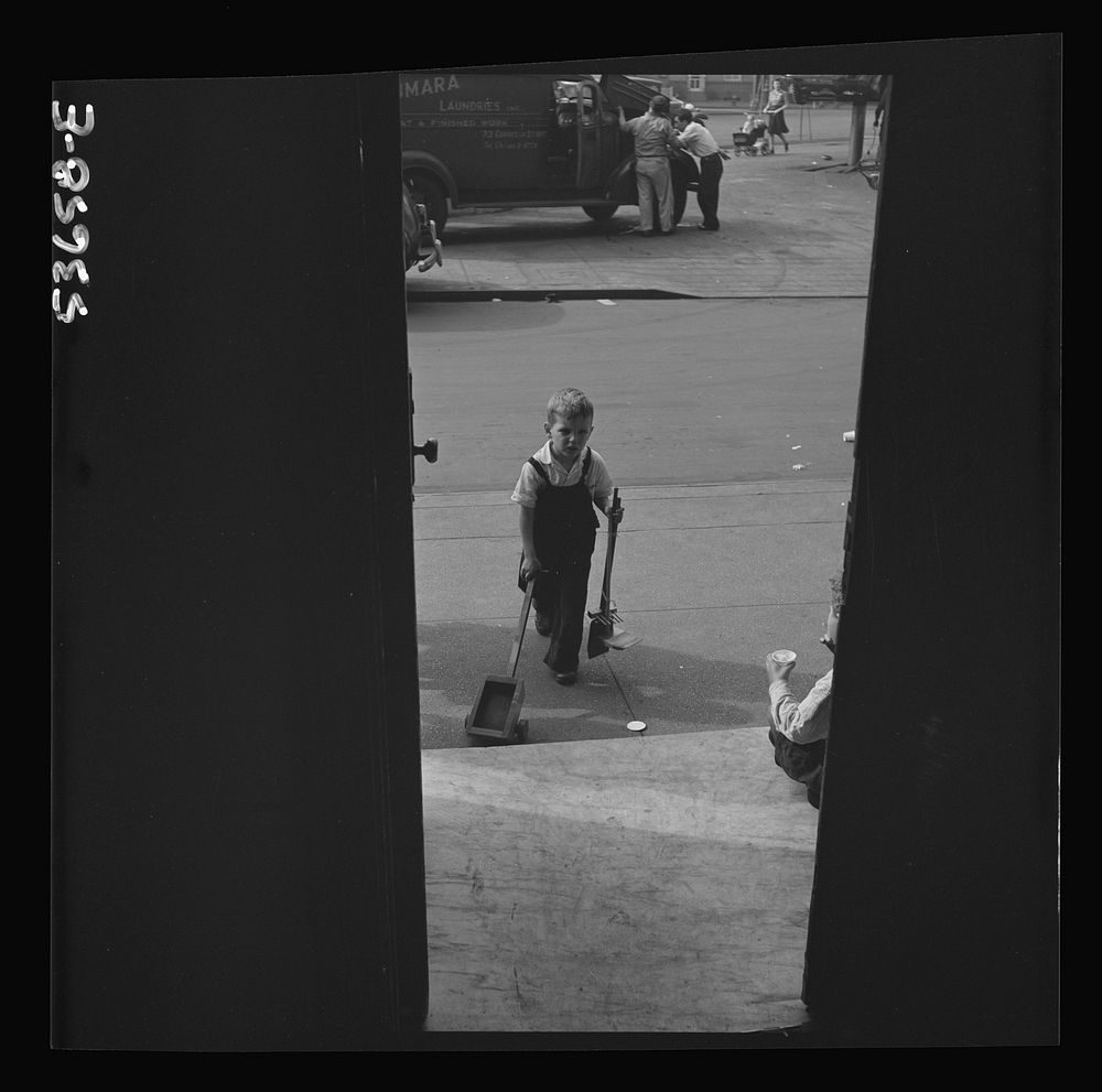 New York, New York. A small boy arriving at Greenwich House where he is enrolled in a nursery school program receives day…