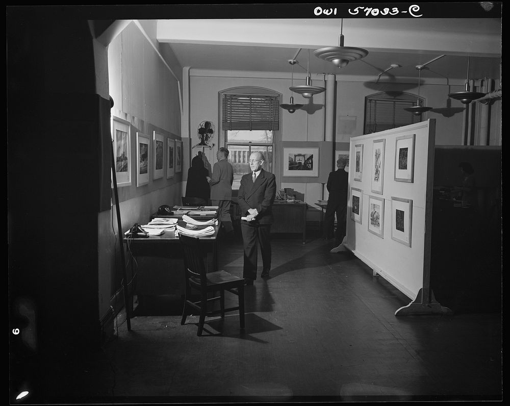 Installation of the United States Office of War Information (OWI) exhibit of original drawings and paintings by artists now…