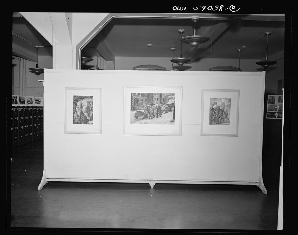 Installation of the United States Office of War Information (OWI) exhibit of original drawings and paintings by artists now…