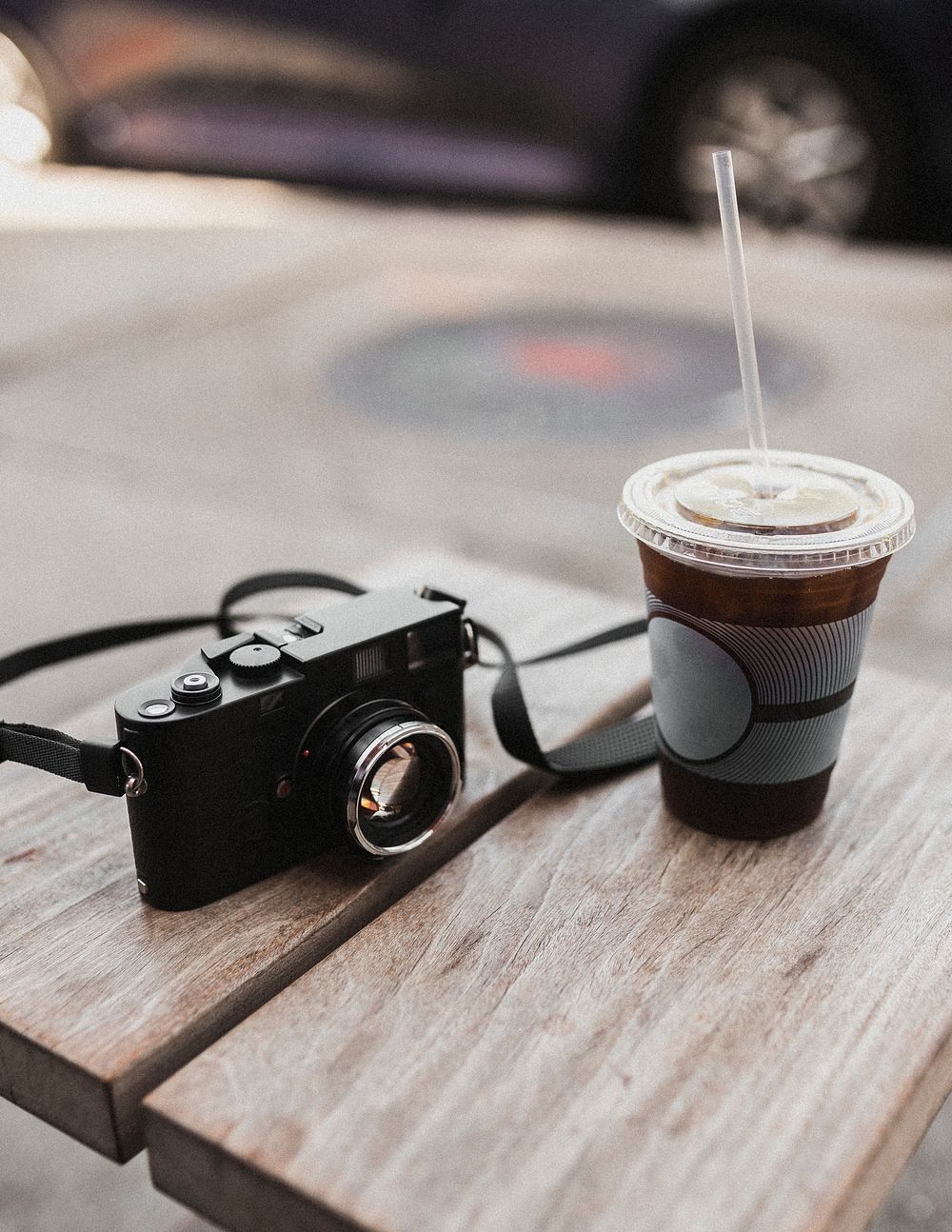 Take away iced coffee and a vintage camera on a table