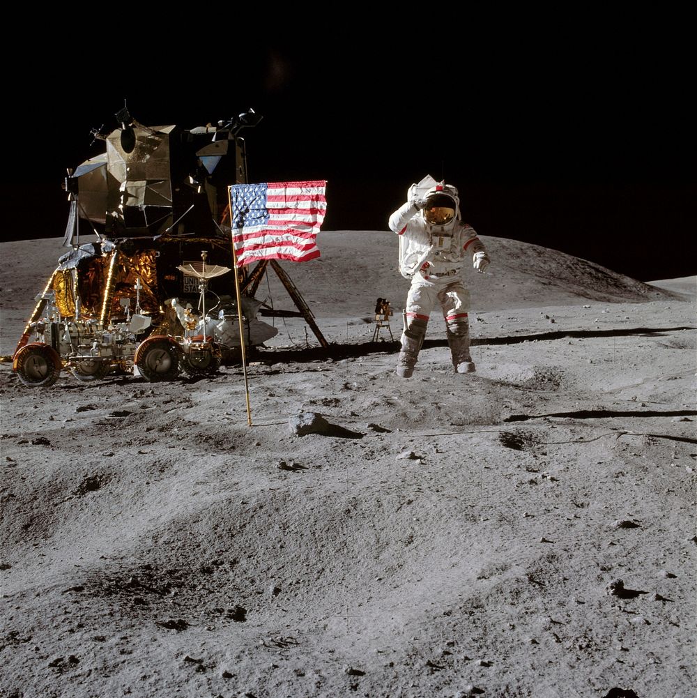 Astronaut John W. Young, commander of the Apollo 16 lunar landing mission, leaps from the lunar surface as he salutes the…