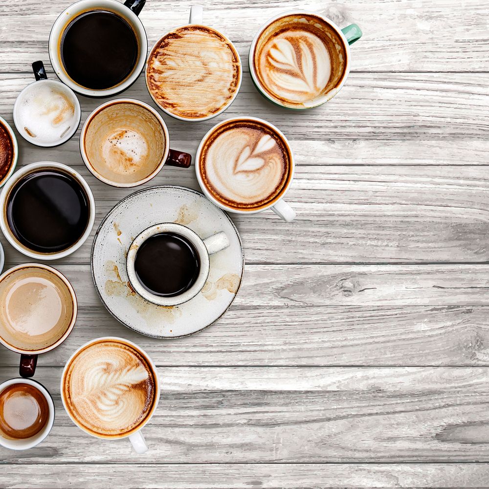 Various coffee cups on a gray wooden textured panel