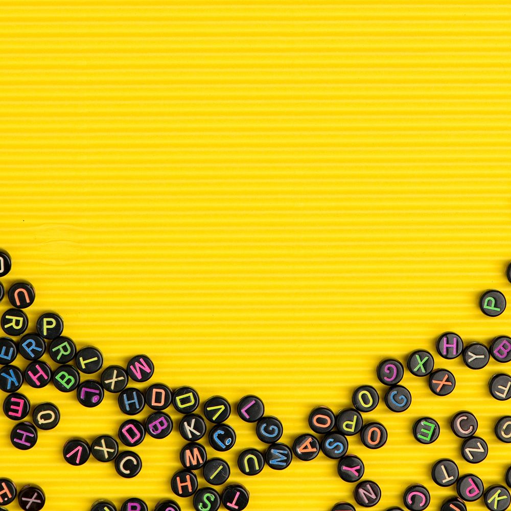 Black alphabet beads yellow background