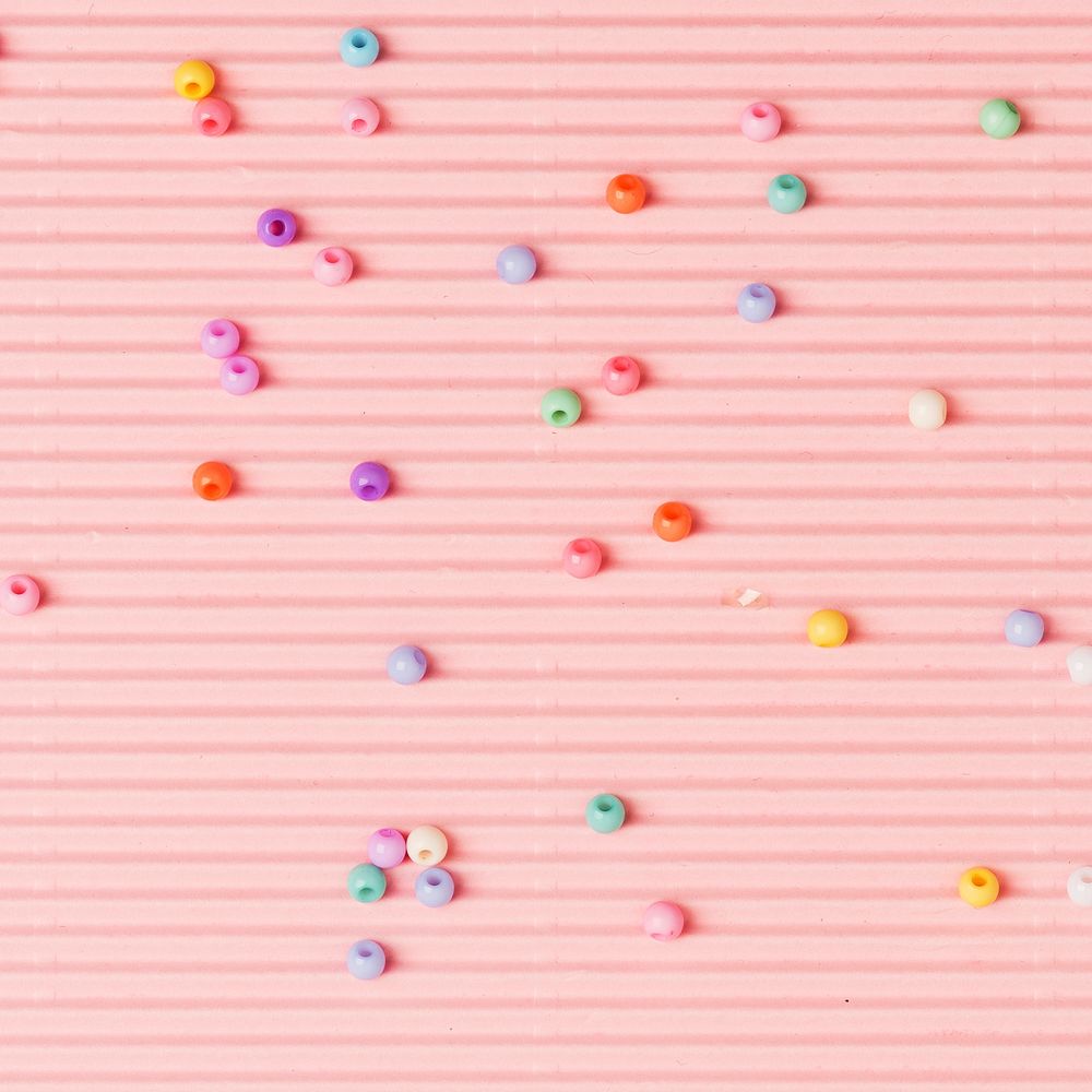 Beads on pink wavy paper background