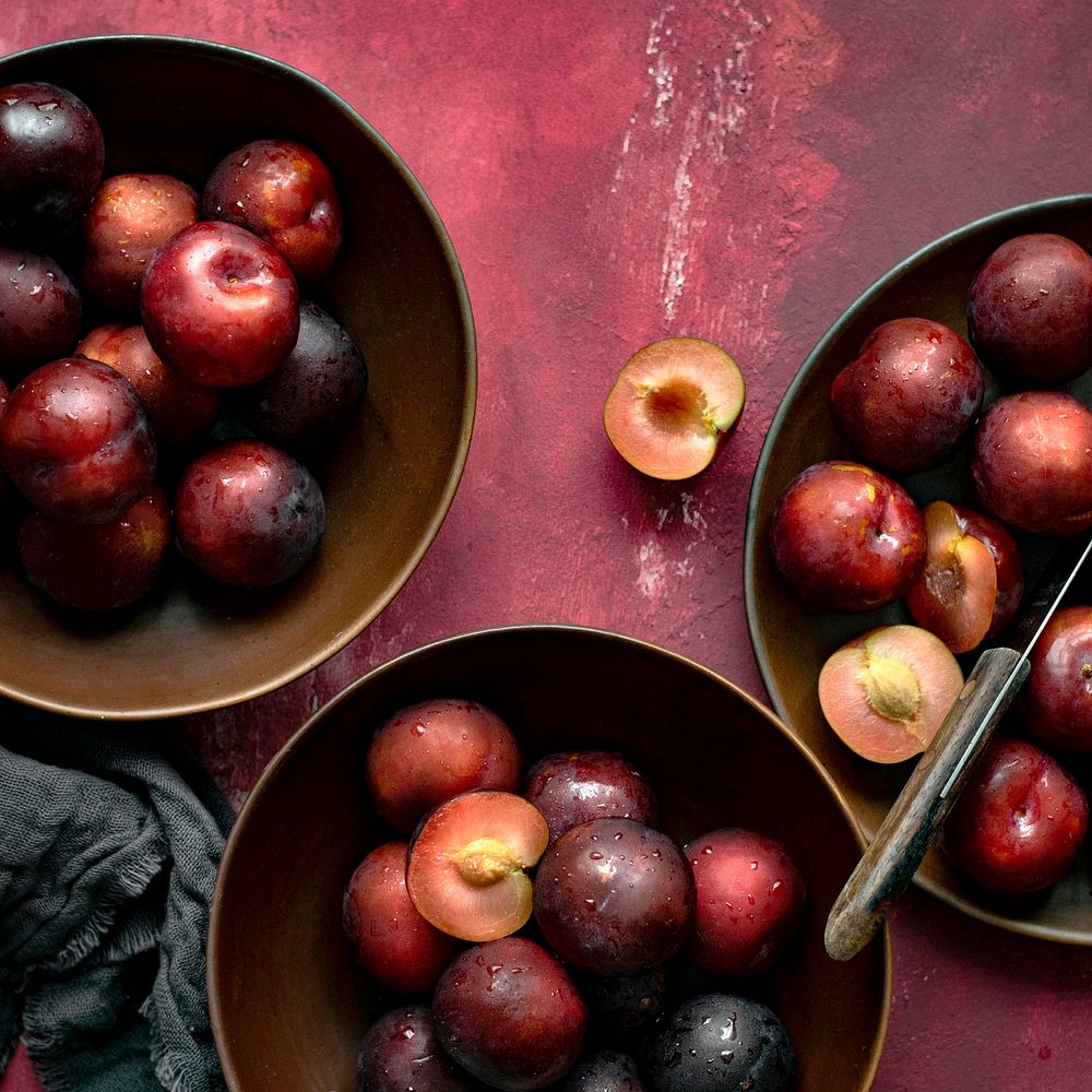 Red plums in a bowl summer food flatlay