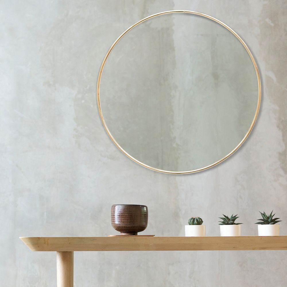 Golden frame on a wall by mini cactuses