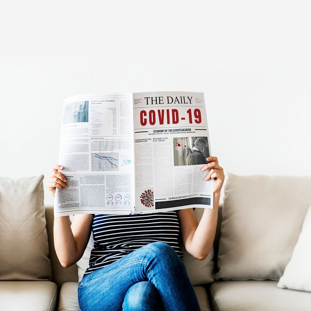 Woman reading coronavirus news from a newspaper