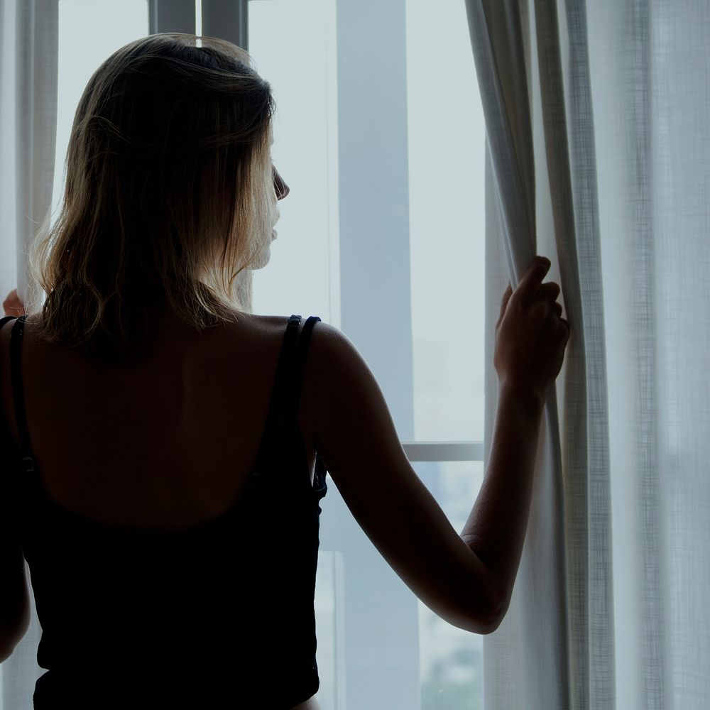 Rear view of a woman standing by the window