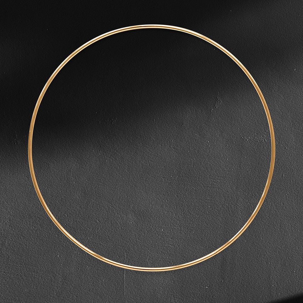 Round gold frame on a black textured background