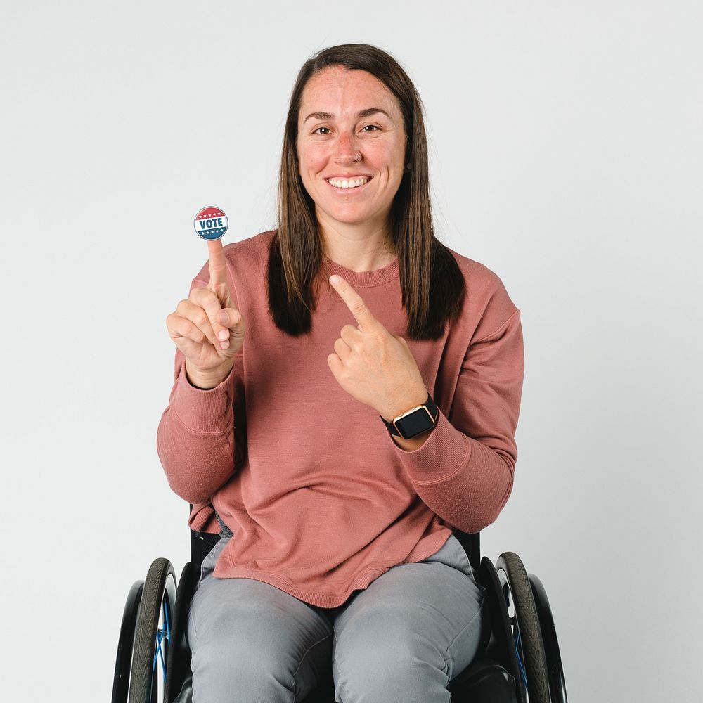 Cool woman on a wheelchair with a vote sticker on her index finger
