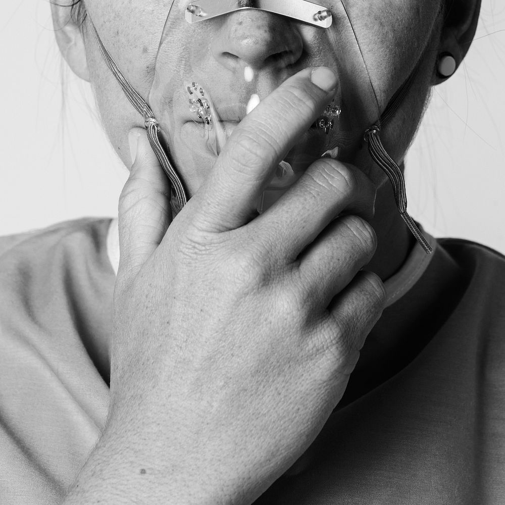 Sick female patient with an oxygen mask