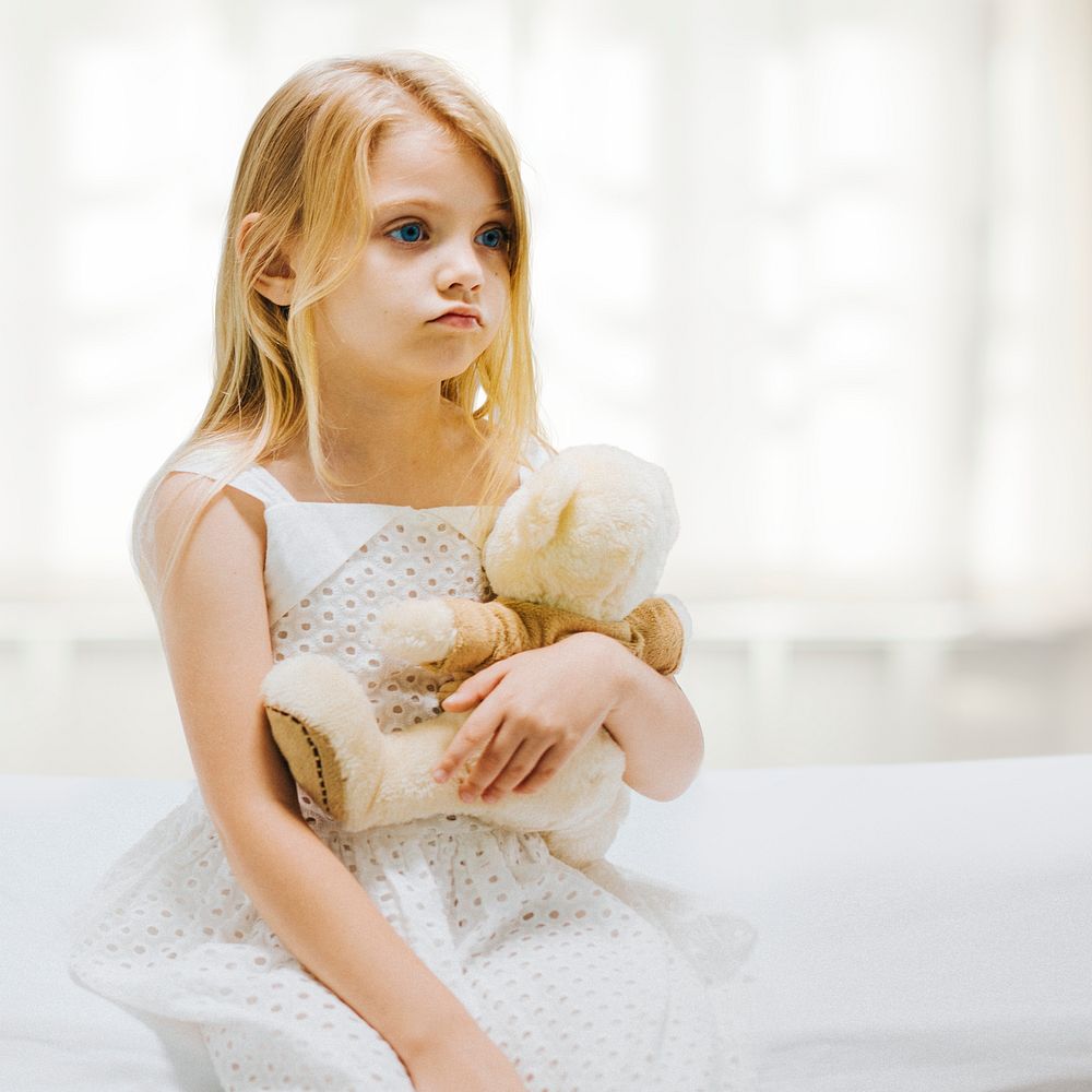 Little girl in hospital holding teddy bear 