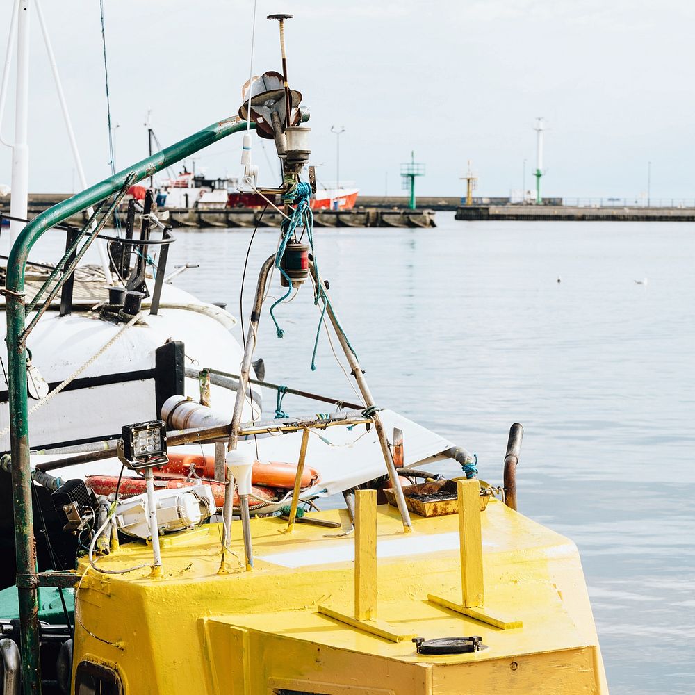 Yellow fishing boat docked in the harbor