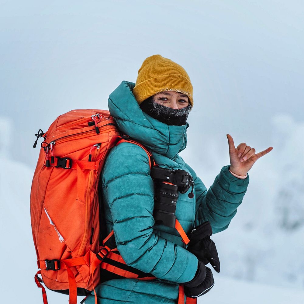 Landscape photographer doing a shaka sign in a snowy landscape