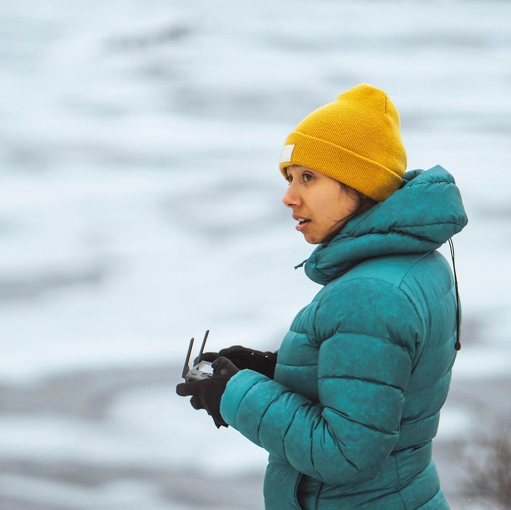 Woman flying a drone in Lofoten, Norway