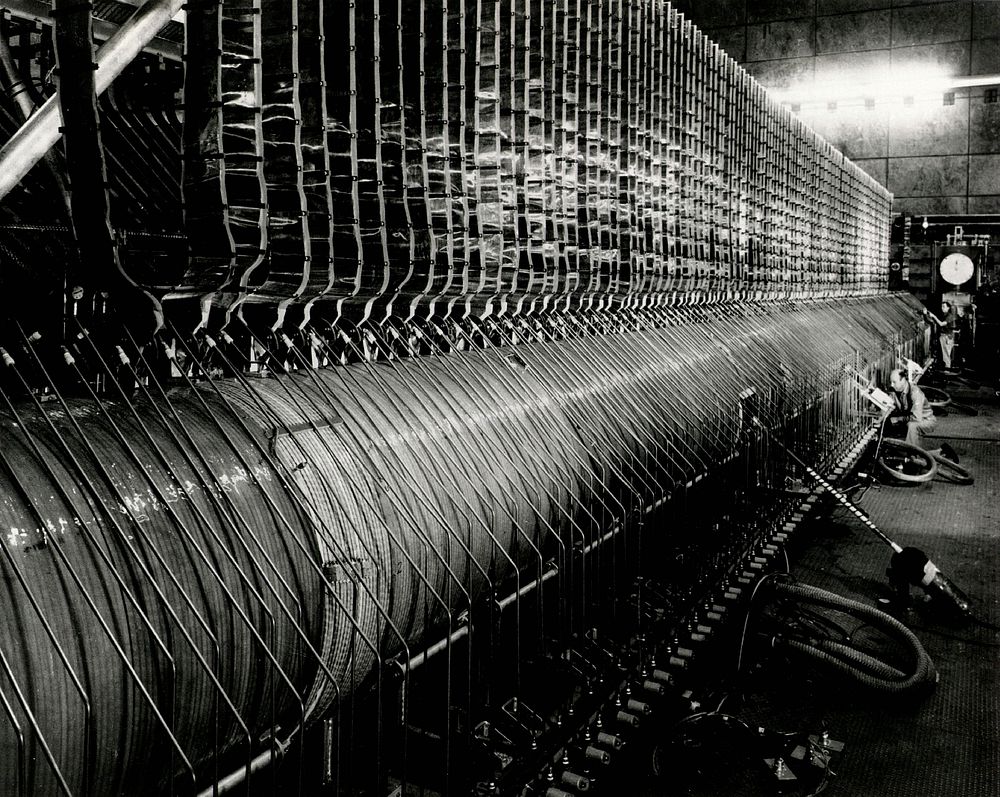 Photo shows a side view of the Astron device. A single-layer solenoid, 92 feet long, is built around an aluminum vacuum…