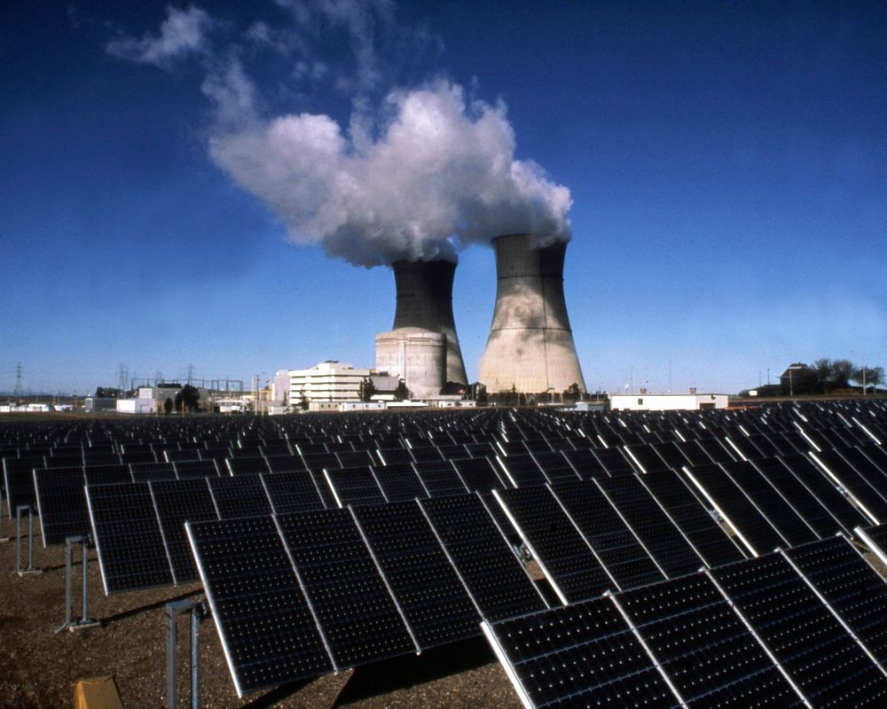 View of smudpv1 photovoltaic panels, with the twin cooling towers of the rancho seco nuclear plant in the background.