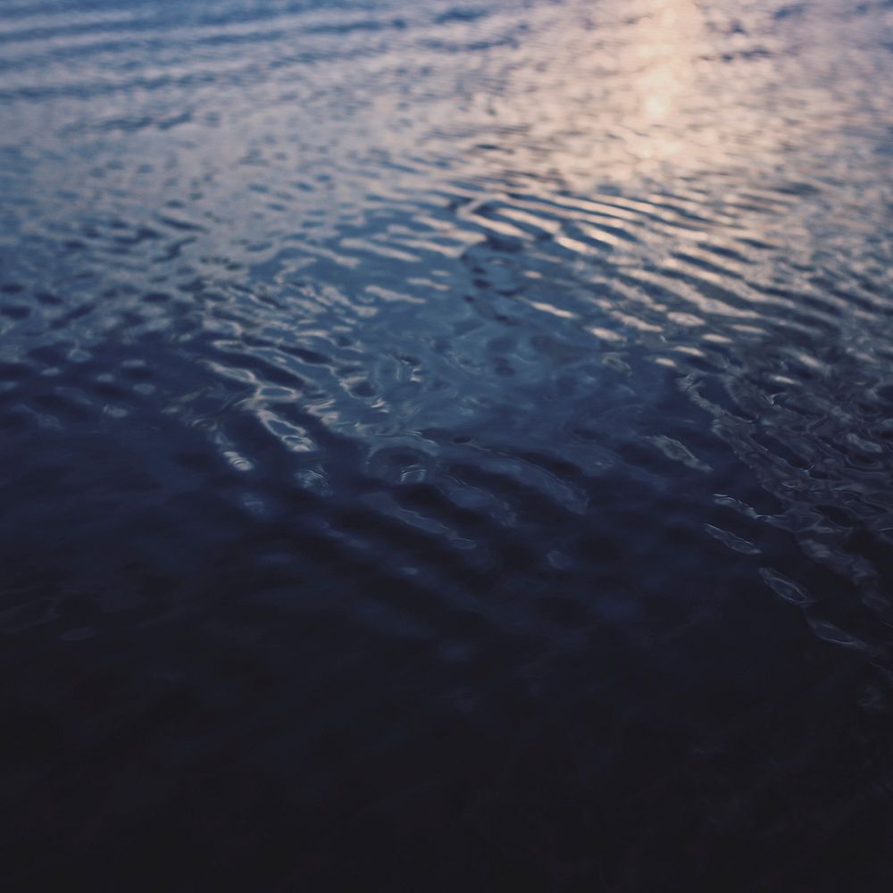Water ripples on dark blue ocean background