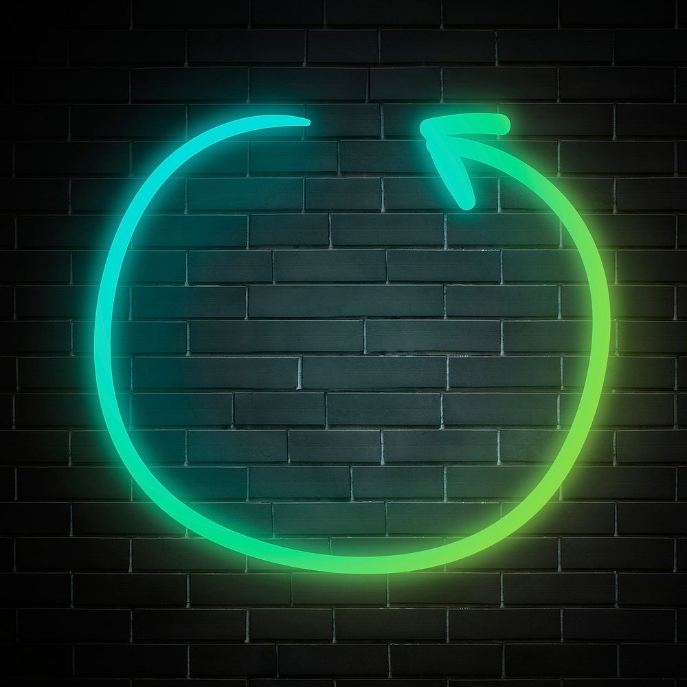 Neon green circle arrow sign on brick wall