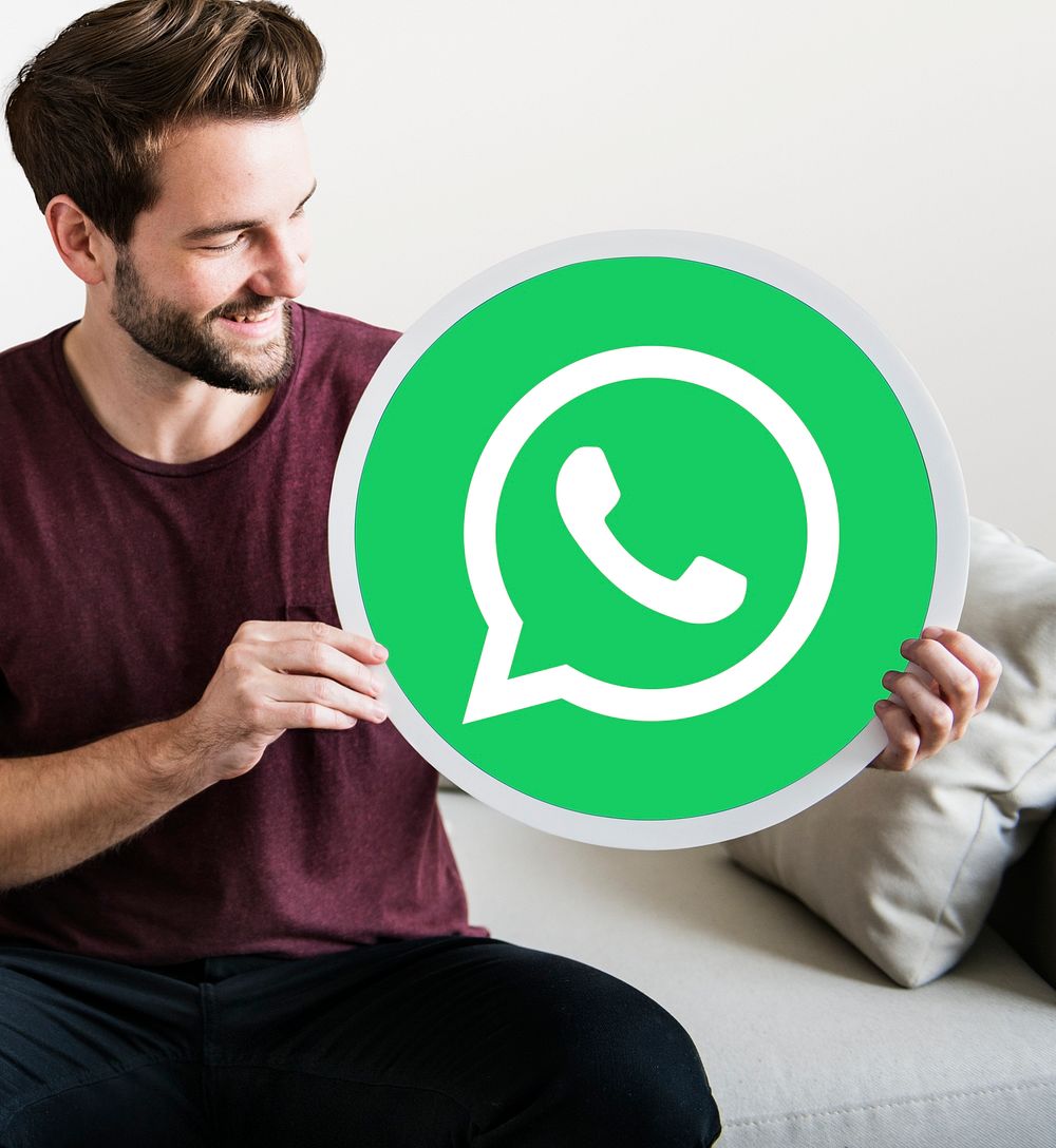 Cheerful man holding a WhatsApp Messenger icon