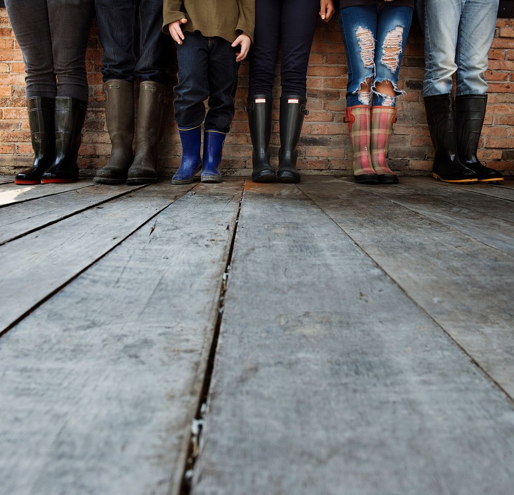 People Wearing Boots Standing Together on Wooden Floor