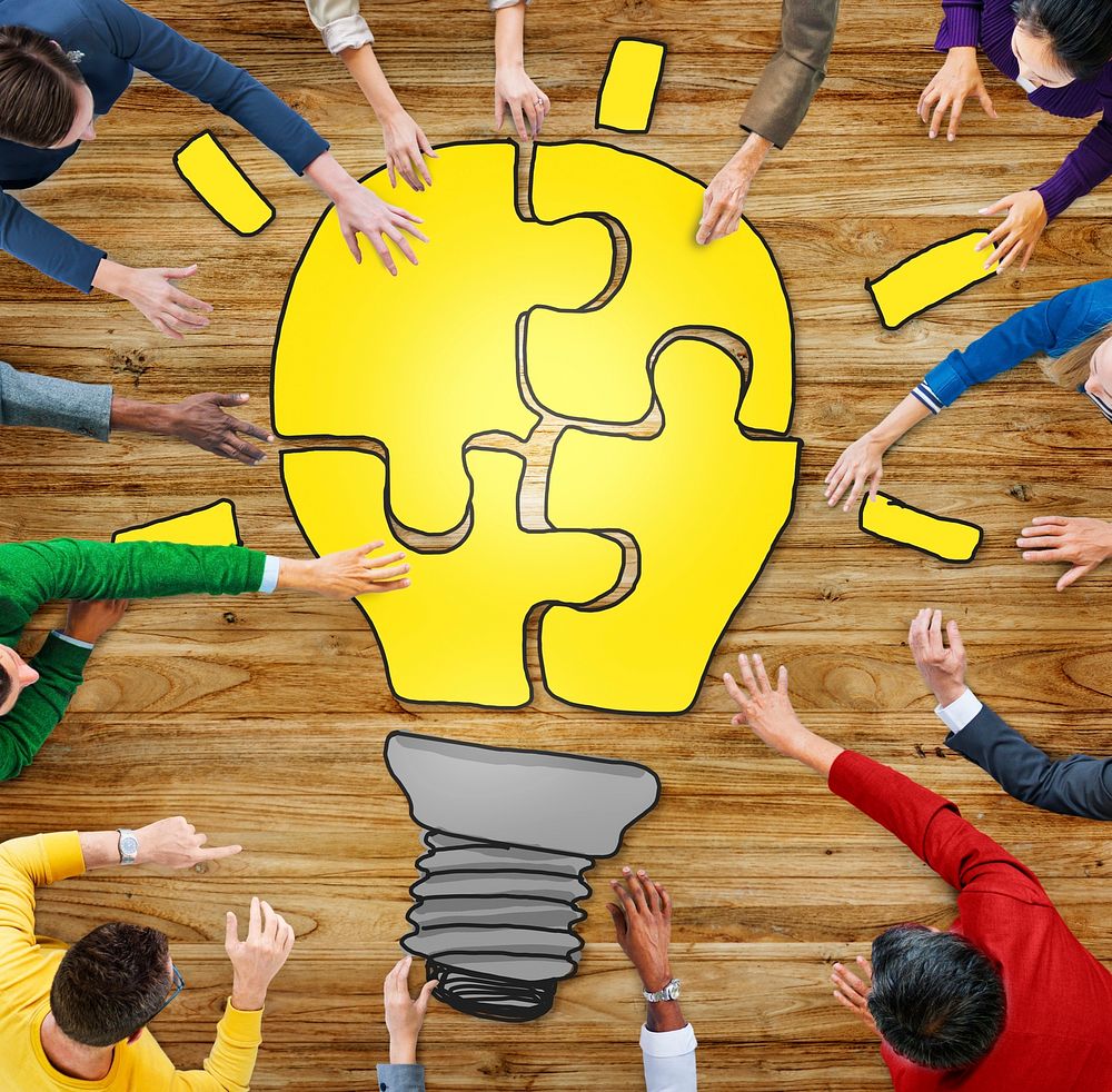 People with Jigsaw Puzzle Forming Light Bulb in Photo and Illustration