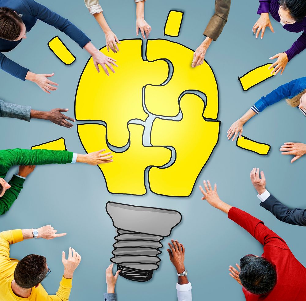 People with Jigsaw Puzzle Forming Light Bulb in Photo and Illustration