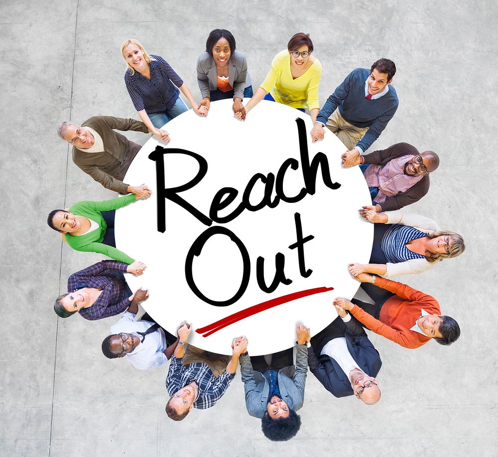 Group of People Holding Hands Around the Word Reach out