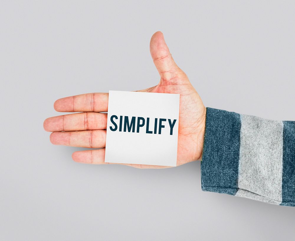 Hand with Sticky Note Showing Simplify Word
