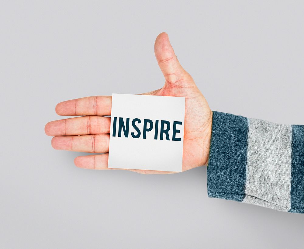 Hand with Sticky Note Showing Inspiration Word