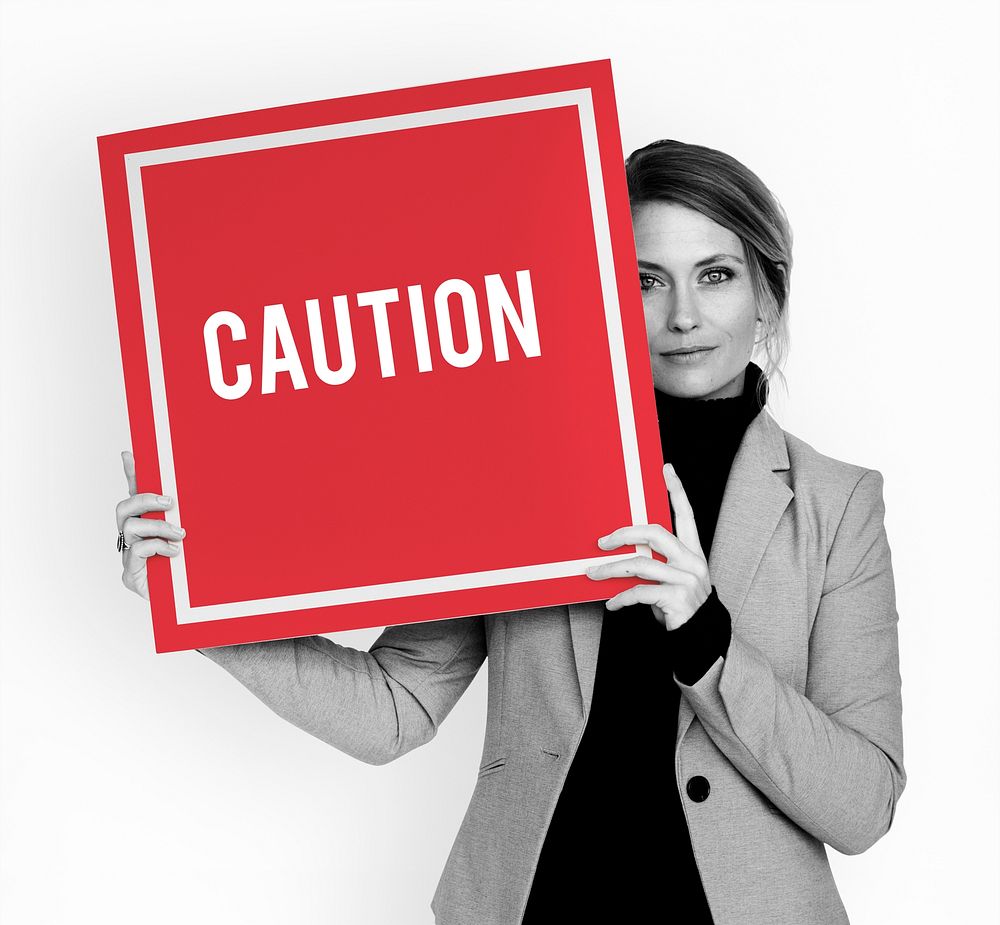 Businesswoman hold caution alert sign